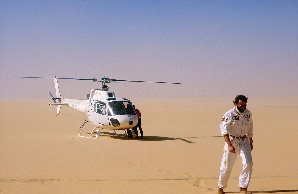 Thierry Sabine em meio ao deserto com um helicóptero 